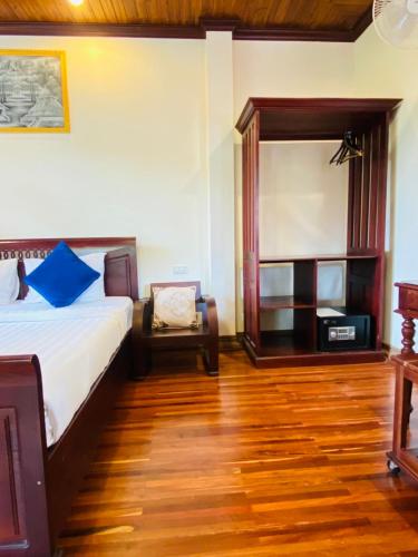 a bedroom with a bed and a chair in a room at Luang Prabang Maison Vongprachan & Travel in Luang Prabang