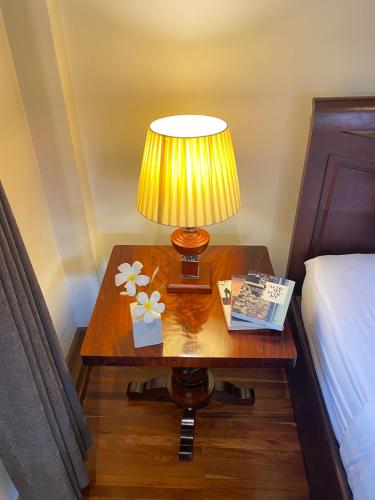 a lamp on a table next to a bed at Luang Prabang Maison Vongprachan & Travel in Luang Prabang