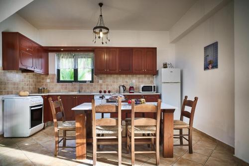 a kitchen with a table and chairs and a refrigerator at Villa Elia by PosarelliVillas in Vryses