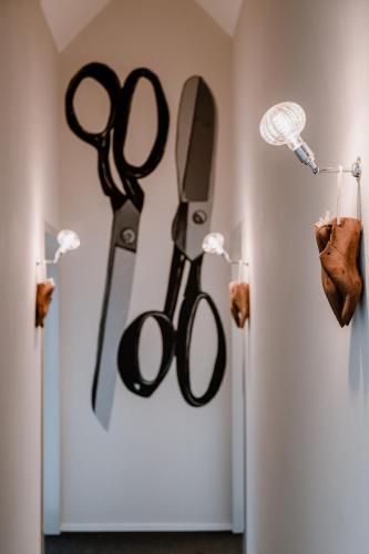 a pair of scissors hanging on a wall at Hotel Müllers Self-Check-In in Arbon