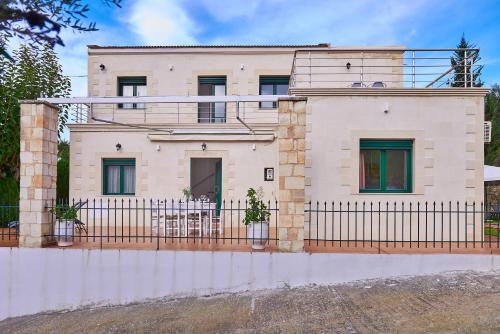 a house with a fence in front of it at Villa Elia by PosarelliVillas in Vryses