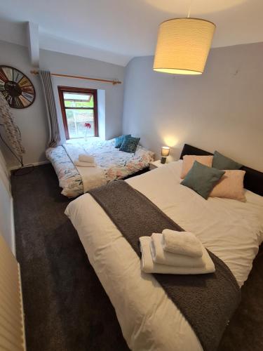 a bedroom with two beds and a window at Old Road Cottage Pet Friendly Outdoors Beaches in Neath