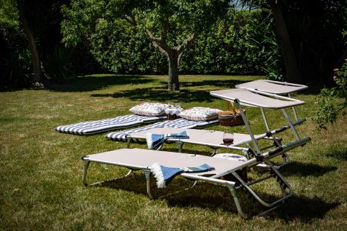 a group of lounge chairs sitting on the grass at Antica Casina B&B di Charme in Pulsano