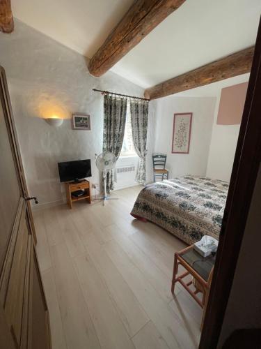 une chambre avec un lit et une télévision à écran plat dans l'établissement Maison Zouz, à Murs