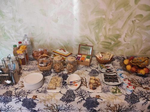 a table topped with plates and baskets of food at La Casetta B&B in Milazzo