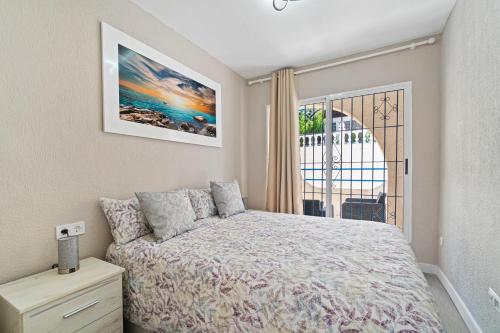 een slaapkamer met een bed en een groot raam bij VILLA-CAPRICHO DUNAS DE LA MATA 3 in Torrevieja