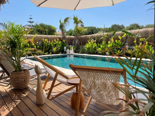 een patio met een tafel en stoelen en een zwembad bij Voger Alaçatı Silence in Alacati