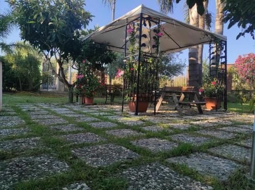 a picnic table and an umbrella in a park at La Casetta B&B in Milazzo