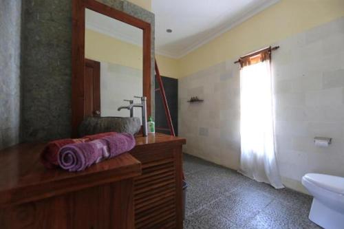 a bathroom with a sink and a mirror at Aaliku Bungalows in Gili Trawangan