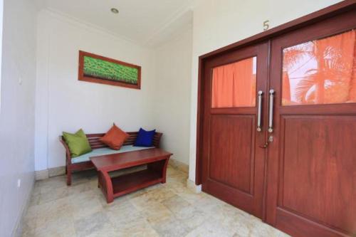 a room with a door and a bench next to a door at Aaliku Bungalows in Gili Trawangan