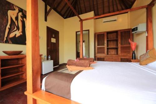 a bedroom with a large bed in a room at Aaliku Bungalows in Gili Trawangan
