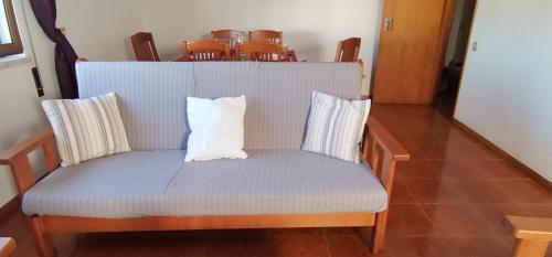 a blue chair with a white pillow on it at Apartamentos Guiomar Campos in Porto Covo