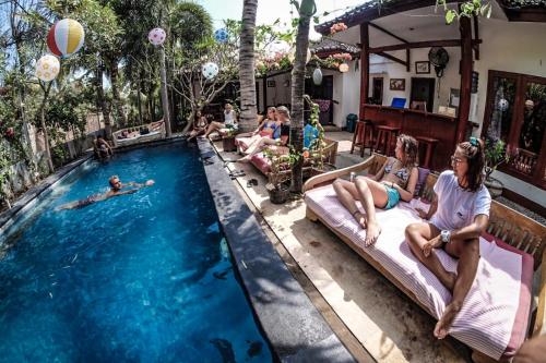a group of people sitting around a swimming pool at Aaliku Bungalows in Gili Trawangan