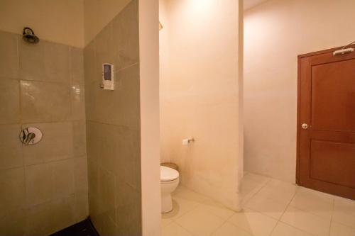a bathroom with a toilet and a shower at Aaliku Bungalows in Gili Trawangan