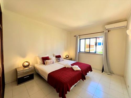 um quarto com uma cama com um cobertor vermelho e uma janela em Algarve Manta Rota Beach by Homing na Manta Rota