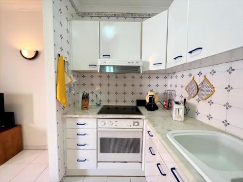 a small kitchen with white cabinets and a sink at Algarve Manta Rota Beach by Homing in Manta Rota