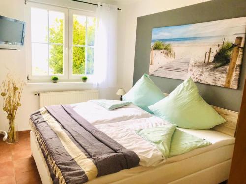 ein Bett in einem Schlafzimmer mit einem Bild vom Strand in der Unterkunft Rügen Träume in Sagard