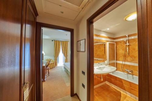 a bathroom with a tub and a sink in a room at Relais Santo Stefano in Sandigliano