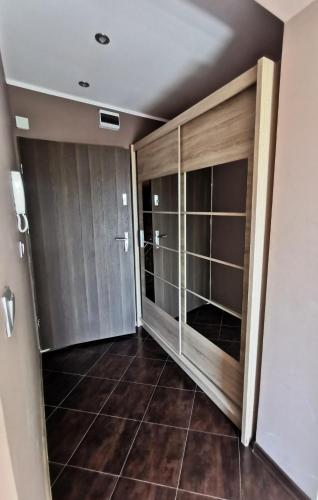 a walk in closet with glass doors and a tile floor at Apartamenty Piekary in Piekary Śląskie