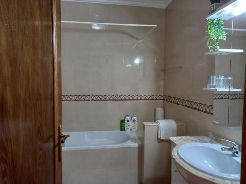 a bathroom with a bath tub and a sink at T2,Casa Sol e Mar 50464/AL in Vila Nova de Milfontes