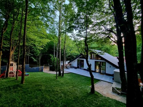 ein Haus inmitten eines Gartens mit Bäumen in der Unterkunft Vila Blanc Valiug Crivaia in Văliug