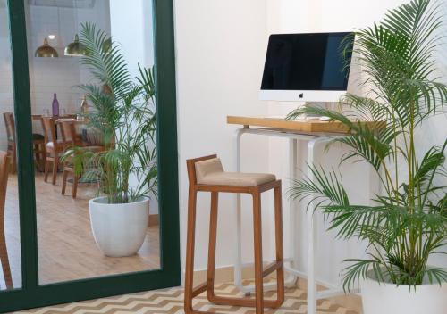 a desk with a computer on it next to plants at Bloom Hotel - Brookefield in Bengaluru