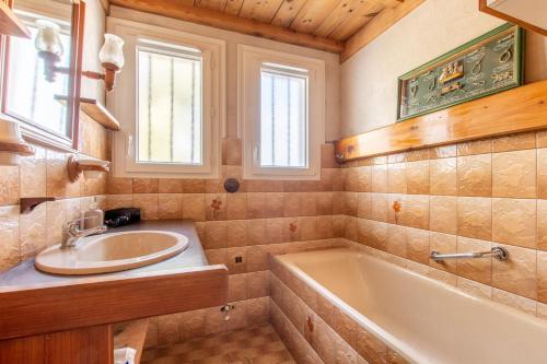 a bathroom with a sink and a bath tub at Maison pour 8 personnes au cœur de la Sauzaie et à 600 m de la plage in Brétignolles-sur-Mer