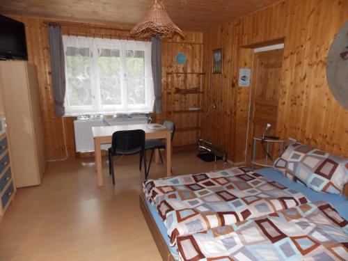 a bedroom with two beds and a desk and a table at Ubytovani U Švýcarů in Turnov