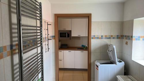 małą kuchnię z białymi szafkami i kuchenką mikrofalową w obiekcie Apartmán Hotel Vomočil Bystré w mieście Bystré