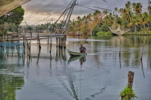 a man is in a boat in the water at Vala House in Cherai Beach