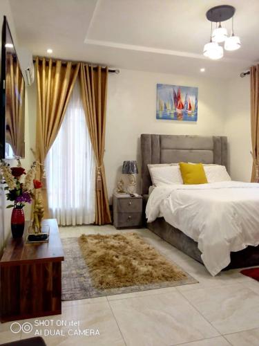 a bedroom with a large bed and a window at Professionals Friendly with Work Station PS5 & near Beaches in Lekki