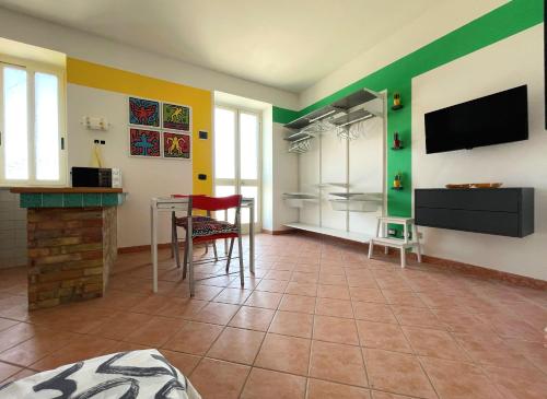 een woonkamer met groene en gele muren en een televisie bij Casa Sunrise al porto turistico in Sciacca