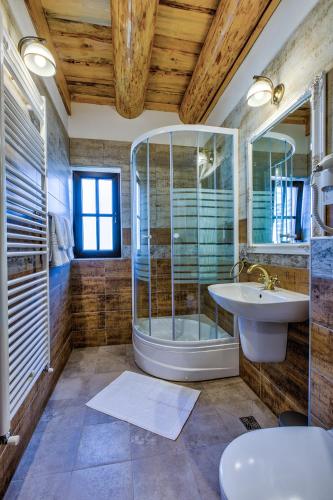 a bathroom with a shower and a sink and a tub at Casa Ambient in Cristian