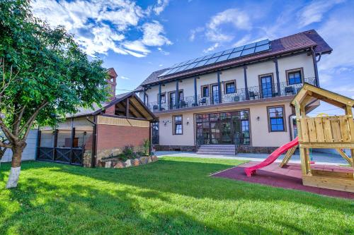 a house with a playground in the yard at Casa Ambient in Cristian