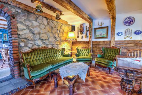 a living room with green couches and a stone wall at Casa Ambient in Cristian