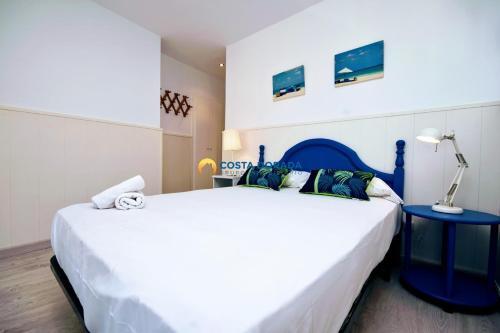 1 dormitorio con 1 cama blanca grande y cabecero azul en Promar Beach, en La Pineda