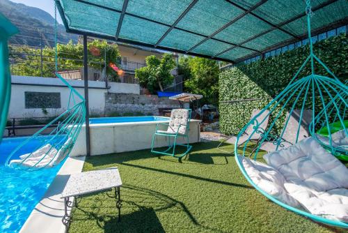a patio with two swings and a swimming pool at Apartments Golden View in Kotor