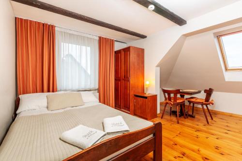 a bedroom with a bed with two towels on it at Willa Ballada in Kuźnica