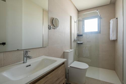 a bathroom with a sink and a toilet and a mirror at ON City Apartments in Matalascañas