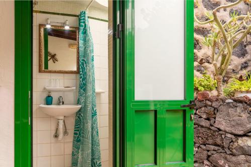 a green door in a bathroom with a sink at El Sitio in Frontera