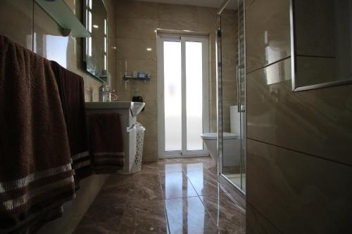een badkamer met een douche, een wastafel en een toilet bij BF RESIDENCE in St Paul's Bay