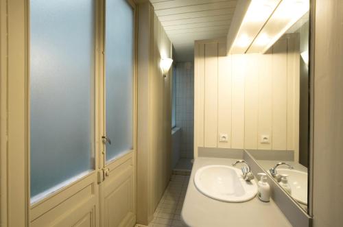 La salle de bains blanche est pourvue d'un lavabo et d'une douche. dans l'établissement Appartement sur les quais de Bordeaux, à Bordeaux