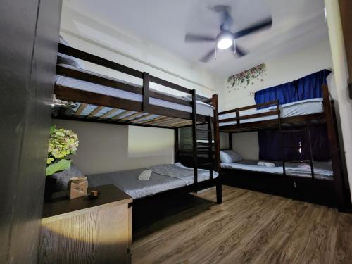 碧瑤的住宿－DMCI Bristle Ridge Condo 318 Cozy 2 Bedroom Unit，客房设有三张双层床和吊扇。