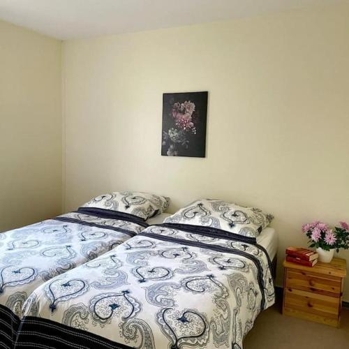 a bedroom with a bed and a picture on the wall at Bungalow im Kiefernwald direkt an der Ostsee (a) in Ostseebad Karlshagen