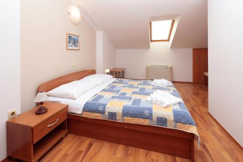 a bedroom with a bed with a blue and white quilt at Resort Trcol in Novalja