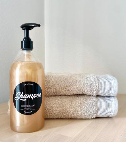 a bottle of soap next to a stack of towels at Studio en face Hopital Nord avec terrasse in Saint-Priest-en-Jarez