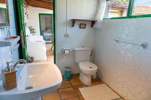 a bathroom with a white toilet and a sink at El Sitio in Frontera