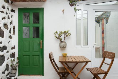 a green door and a table and chairs on a porch at El Sitio in Frontera