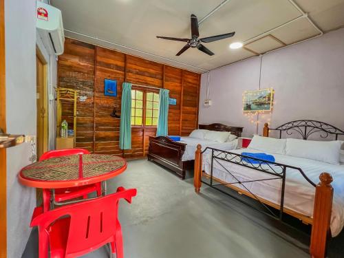 a bedroom with two beds and a table and chairs at Betik Garden Home in Machang