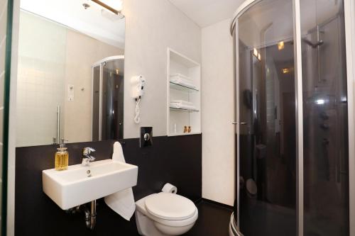 a bathroom with a sink and a toilet and a shower at Arctic Comfort Hotel in Reykjavík